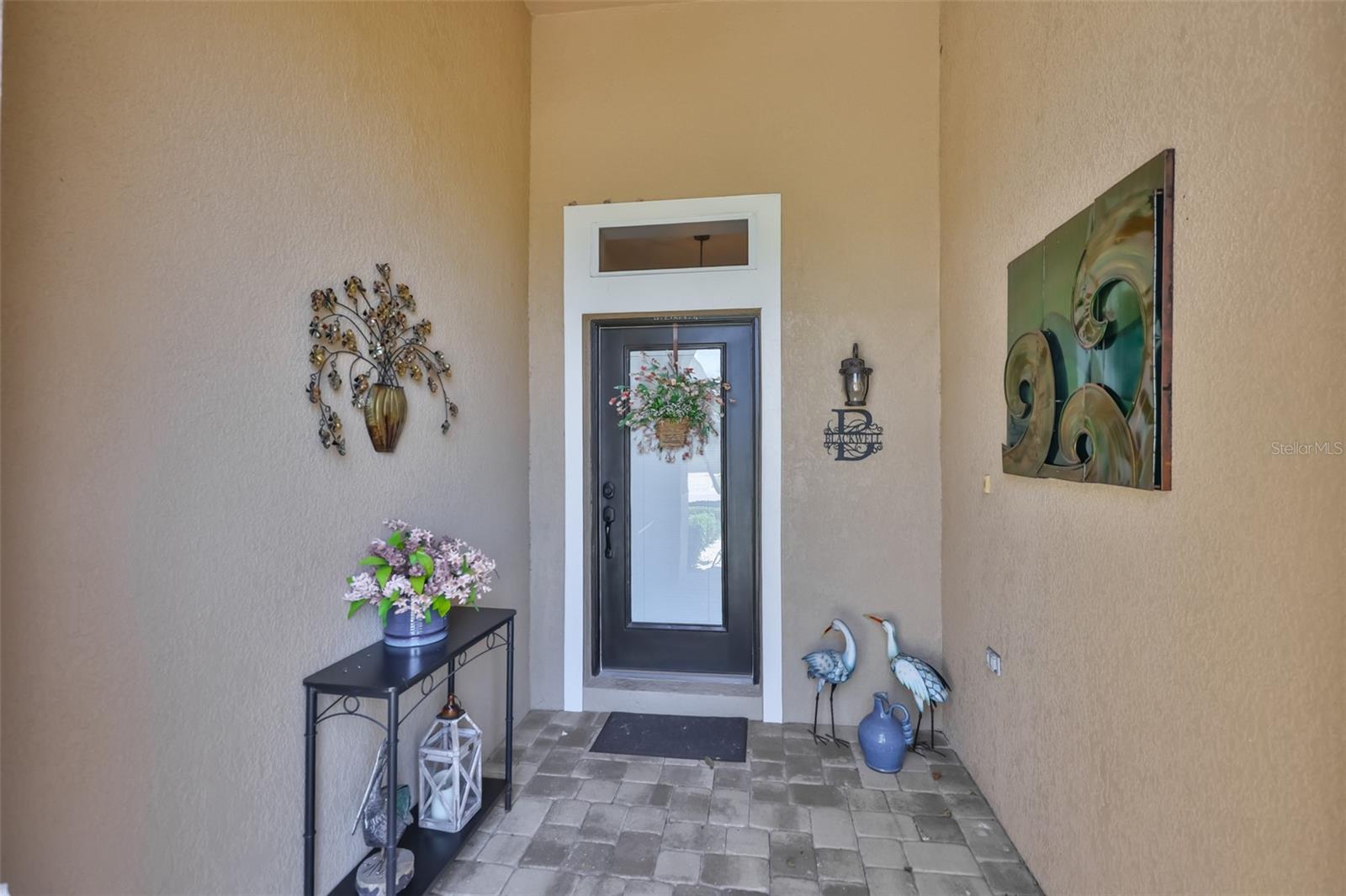 Perfect entrance to welcome guests out of the elements with high ceilings and a lovely glass door with transom to allow lots of natural Florida sunshine into the home.
