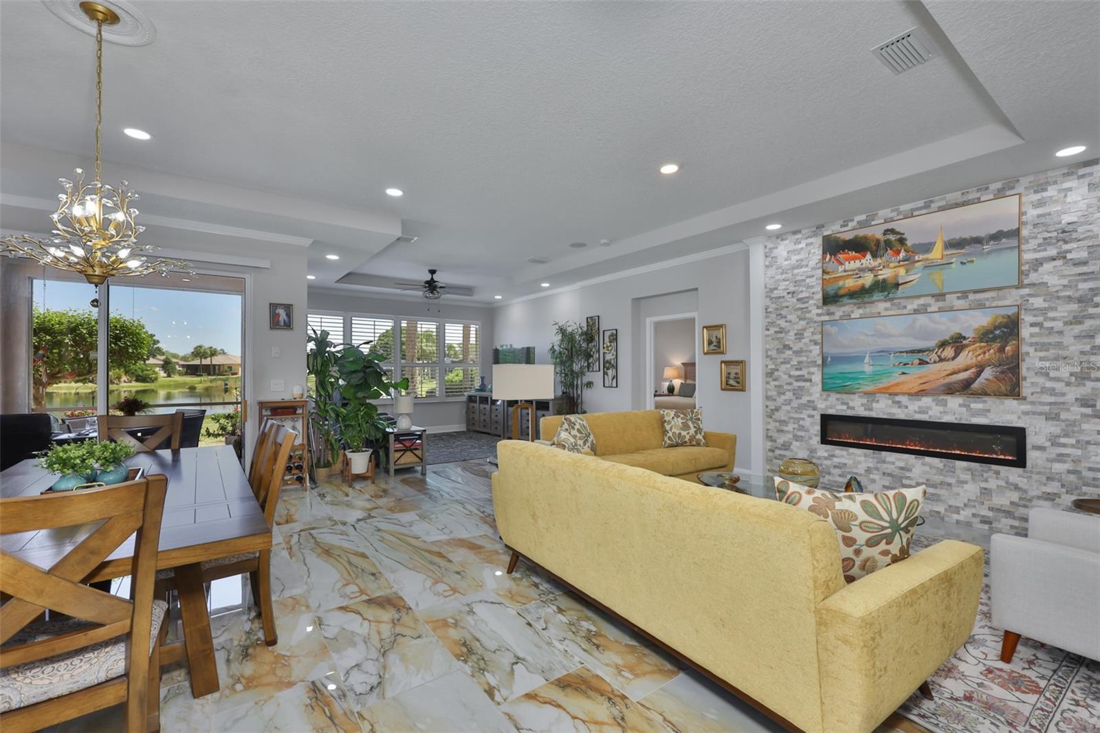 That "European" feel is everywhere in this home.  Exquisite tile flooring, accent wall with a modern electric fireplace, neutral paint tones, crown molding and custom light fixtures.