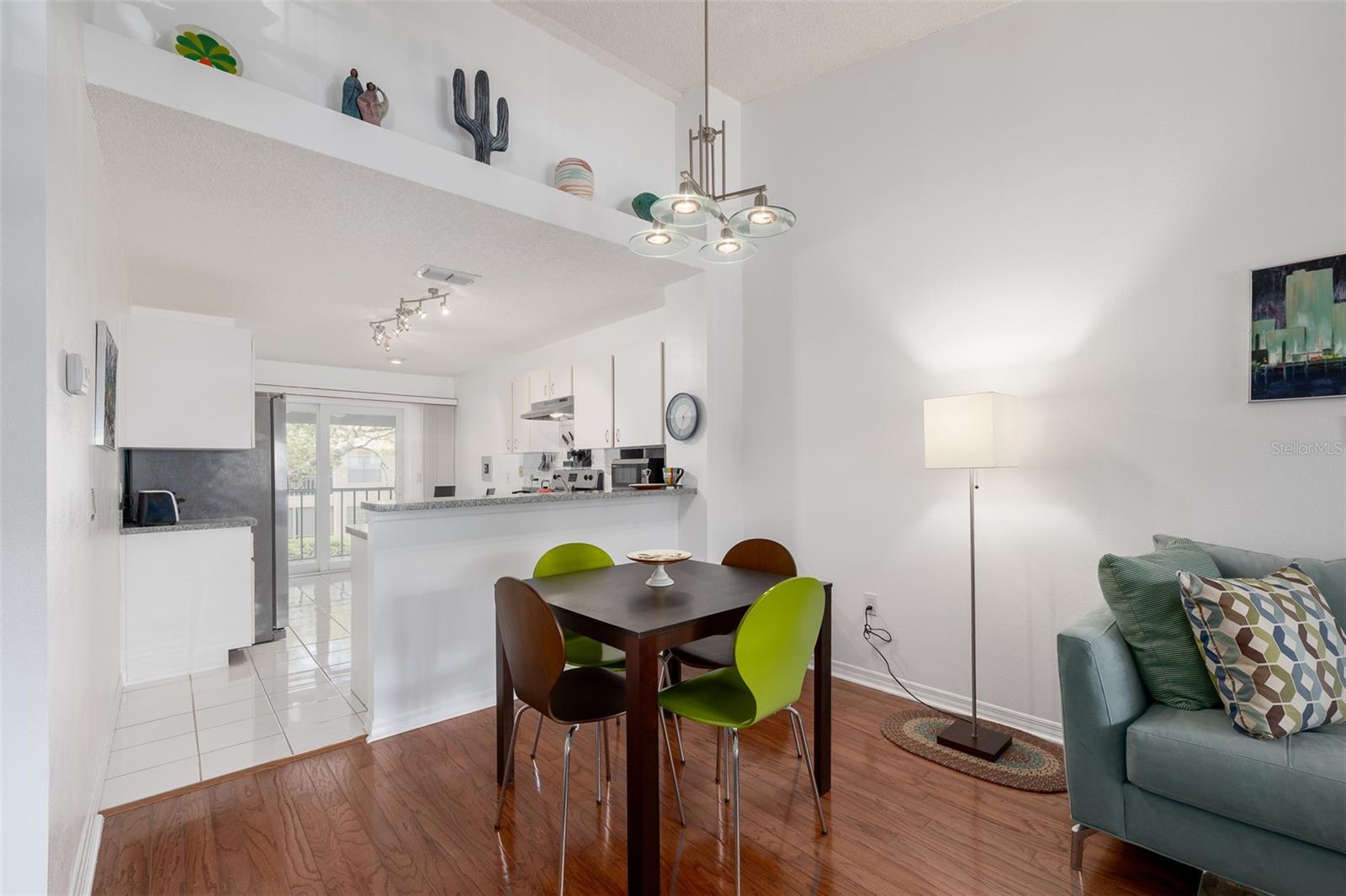 Dining room, accent built-in shelves, kitchen, more eat-in space, glass sliders onto screen enclosed patio.