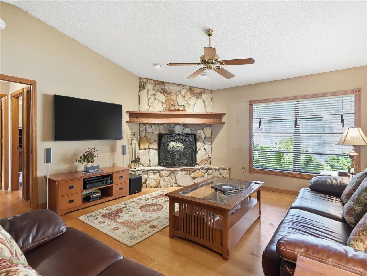 Family Room shows fireplace, hallway to bedrooms 4 and 5. Triple sliders to access patio/pool area