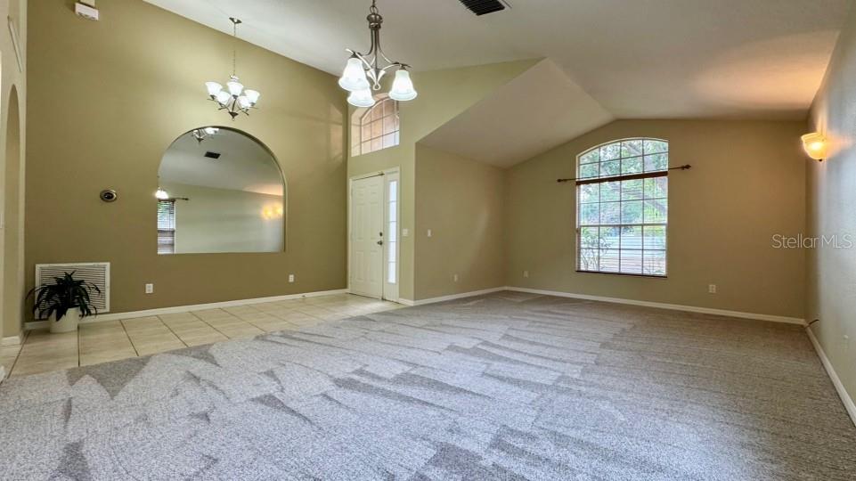 Front door with transom and skylight enters into a large foyer, living room and dining area with brand new carpet (April 2026)