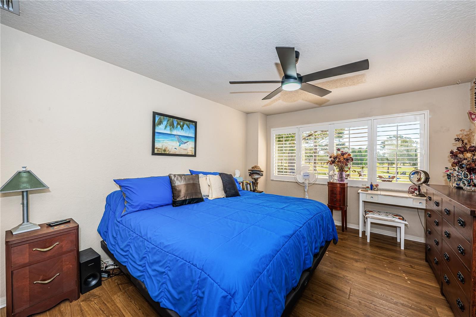 Master Bedroom with fan, Plantation Shutters, Plant Shelf, newer laminate floors & 7x7 Walk-in Closet