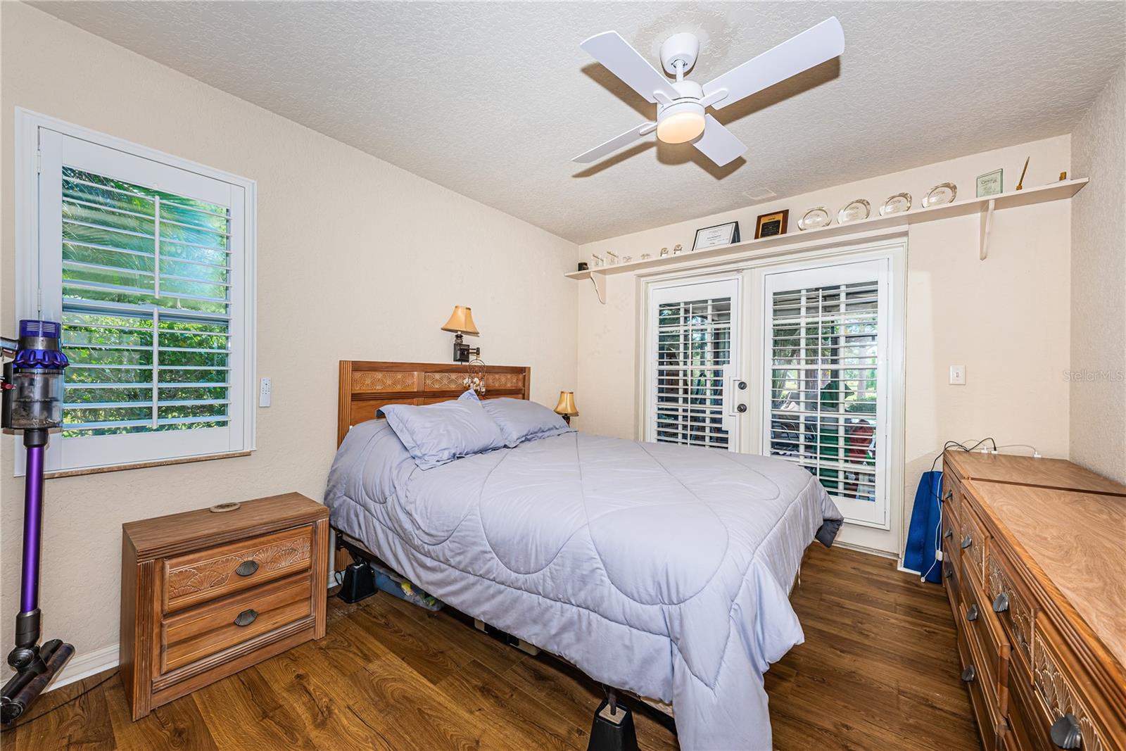 Bedroom with newer Laminate floors, Plant Shelf and French Doors to the Screened Lanai.