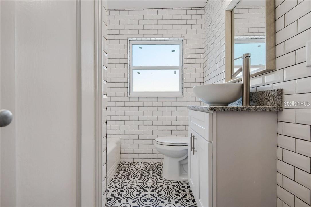 Second bathroom, featuring bath-tub and shower combo.