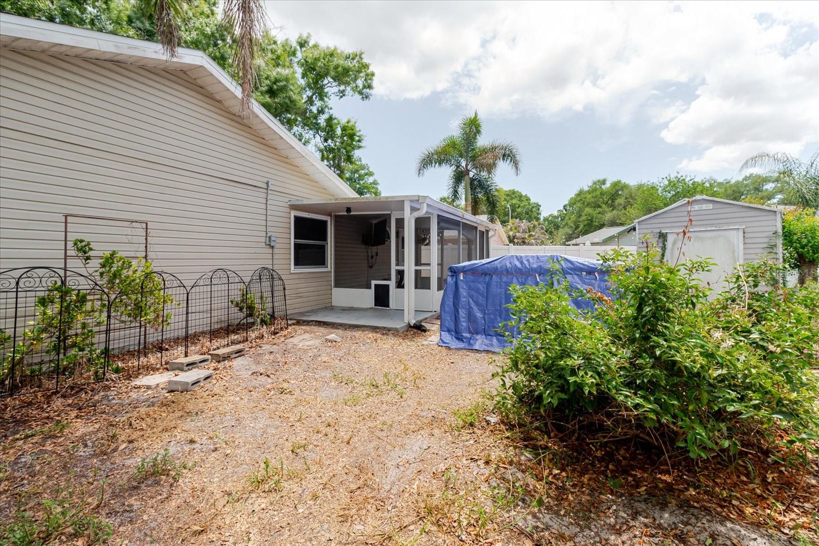 Backyard with swim spa and screen porch; shed