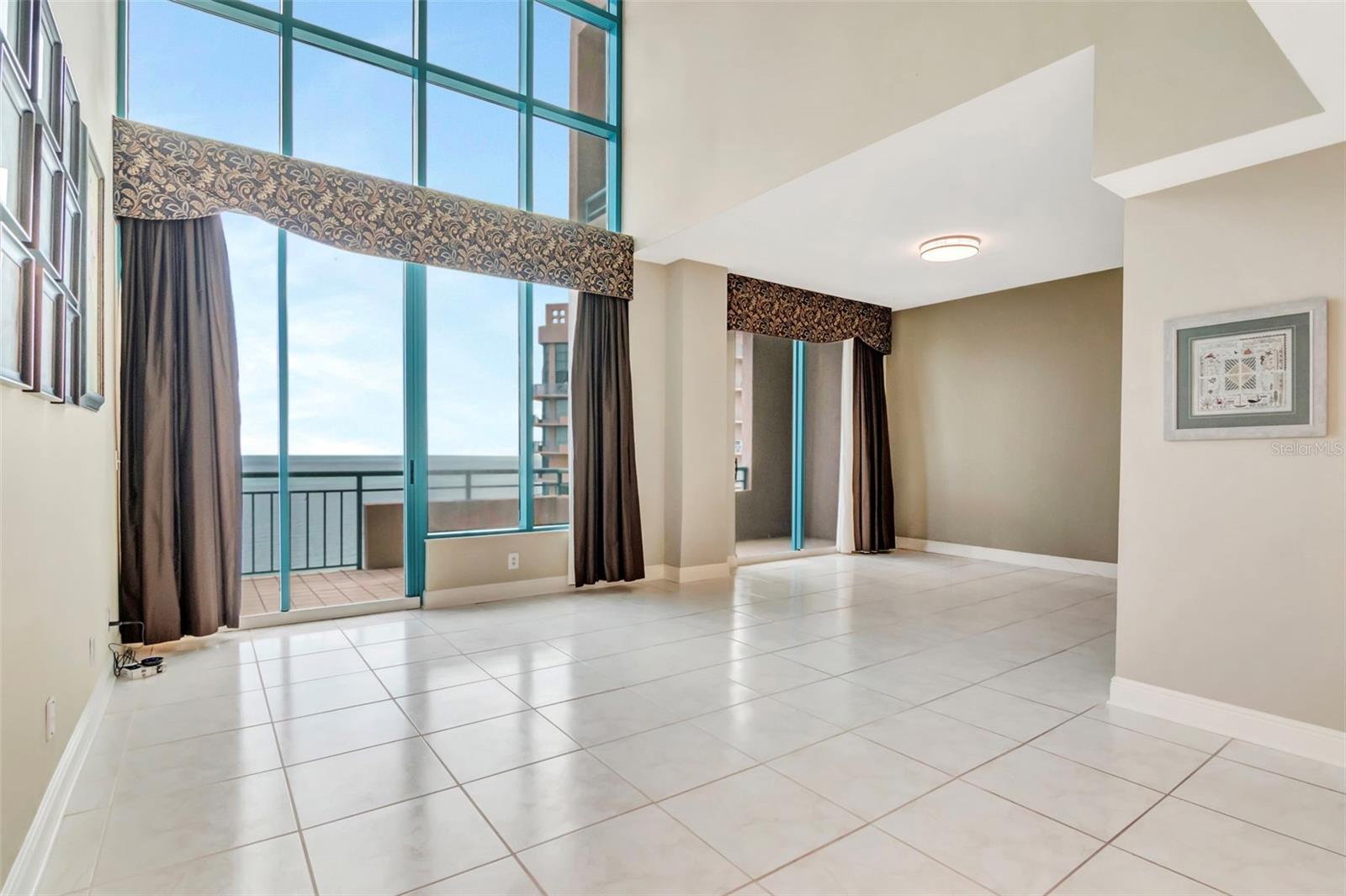 Two story windows in massive living room.   You notice the views as soon as you walk in