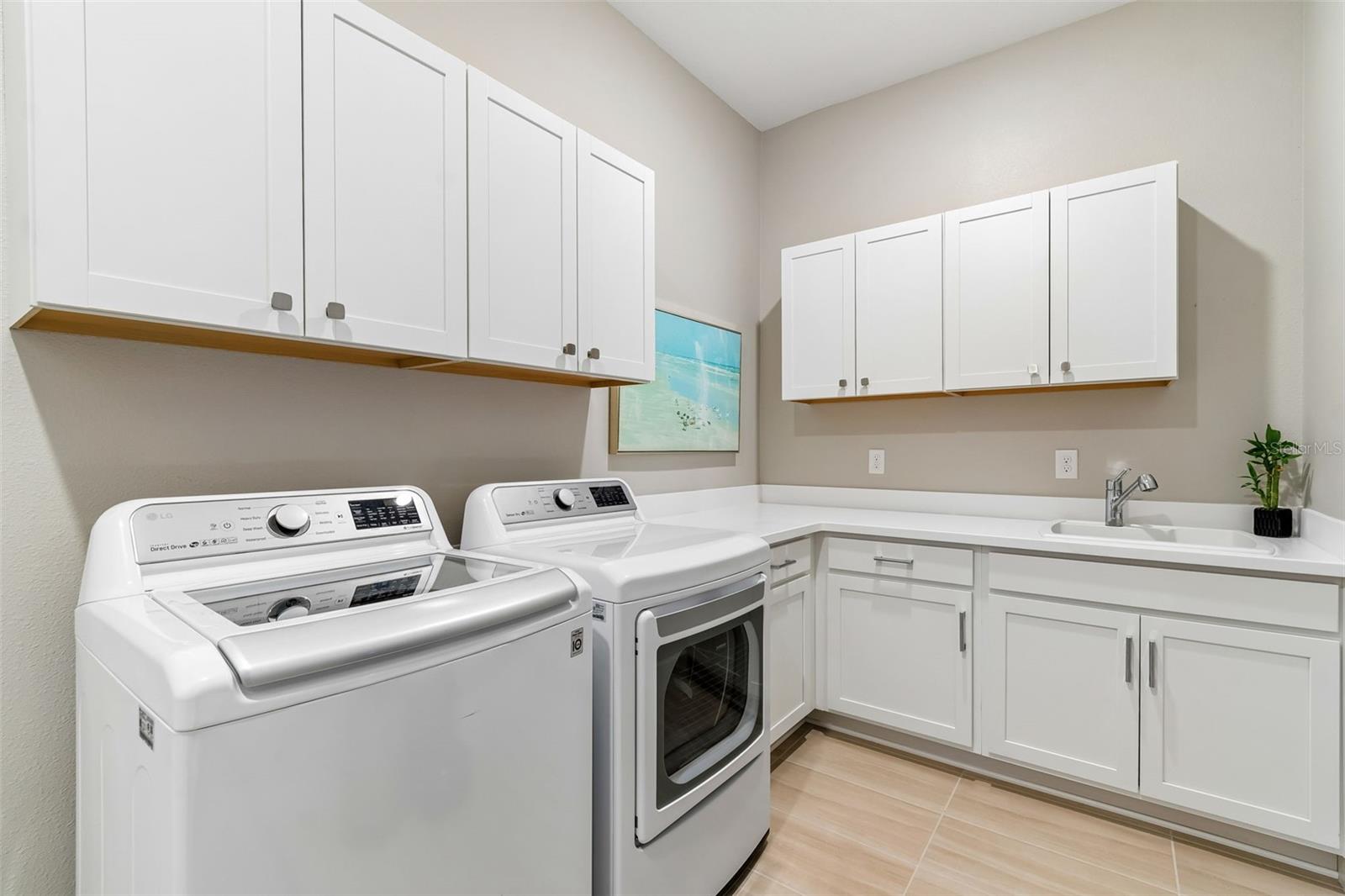 Upgraded laundry room with sink and cabinets