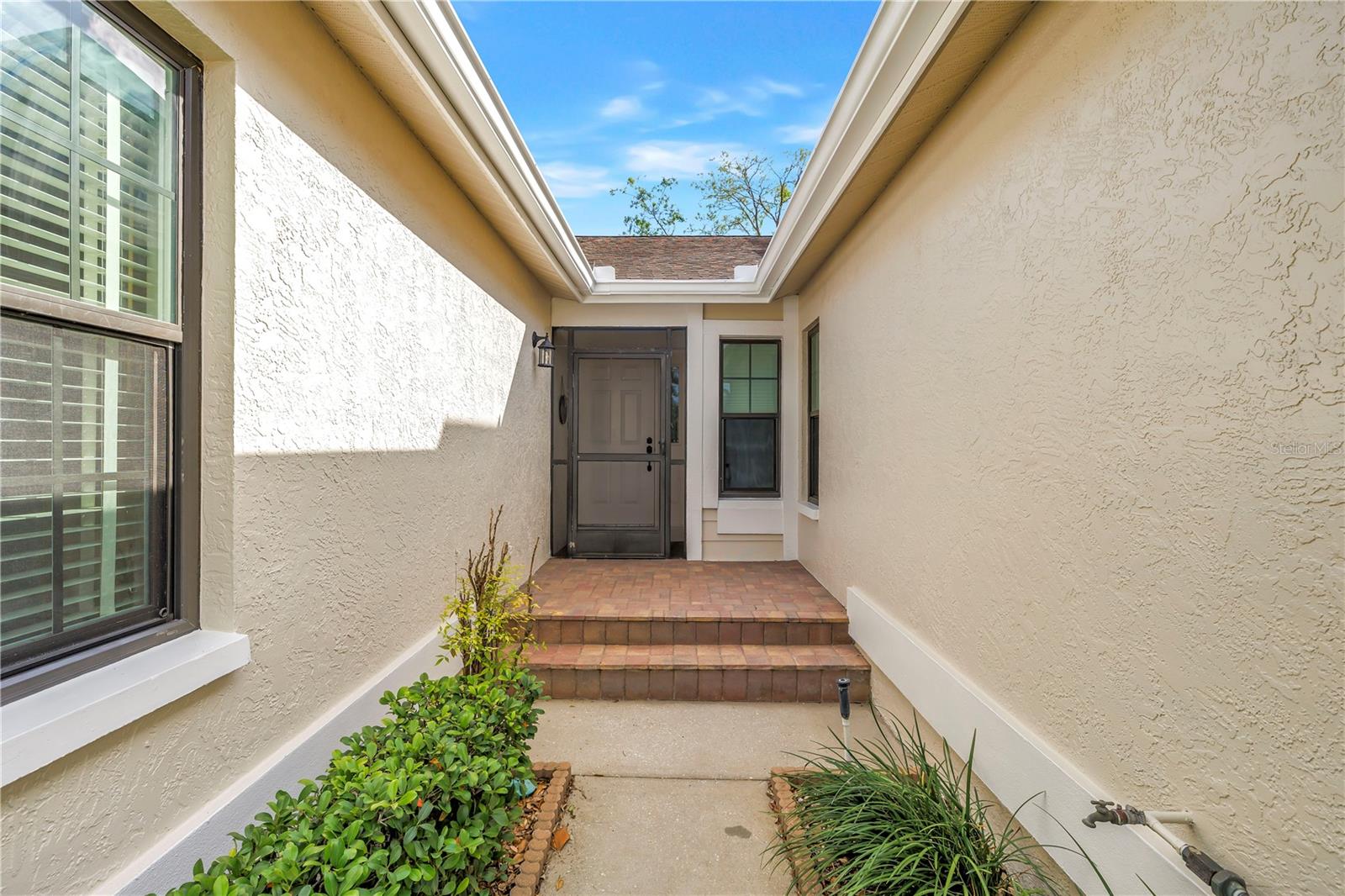 Private alcove entry with screened front door for letting those exceptional breezes off the water flow through