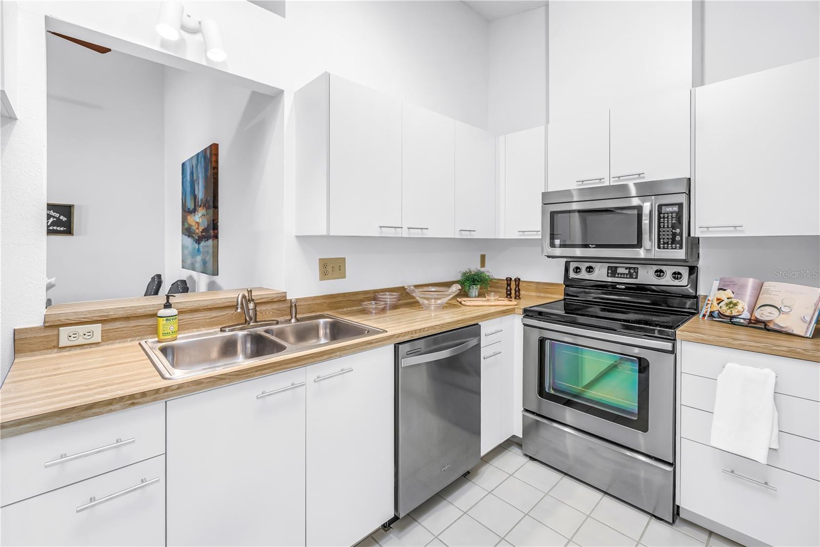 Stainless appliances, White cabinetry, and open to the dining and living space