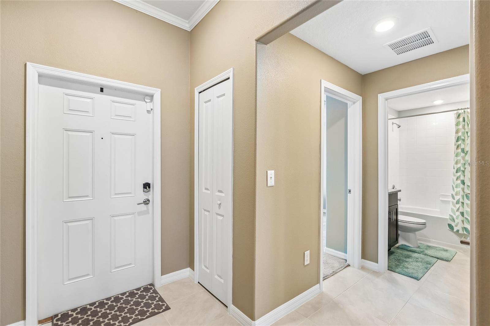 Entry / FoyerEntry foyer with tile flooring, crown molding, and recessed lighting. Coat closet adjacent to the front door; secondary bathroom visible from the hallway.