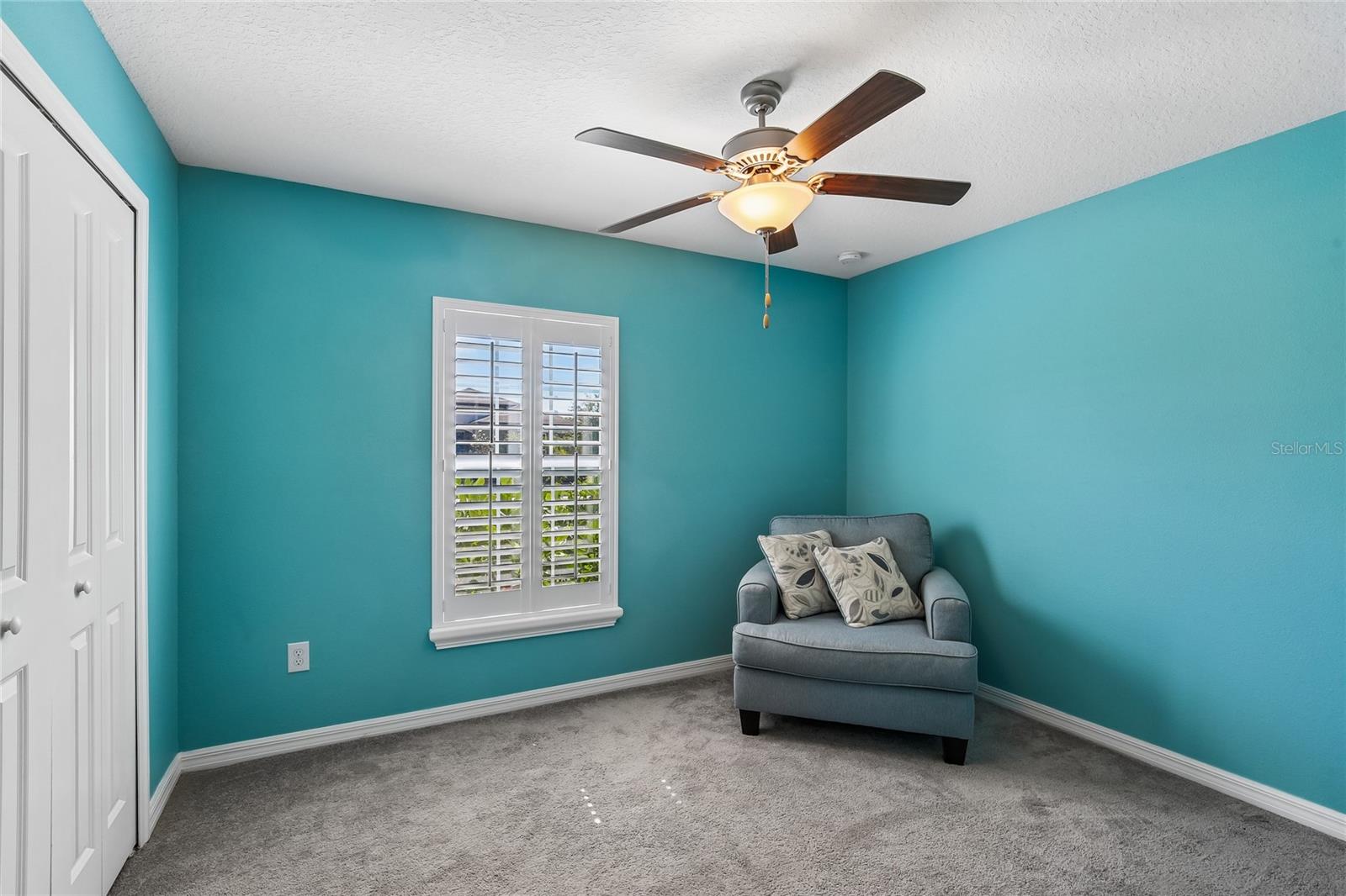 Secondary BedroomSecondary bedroom with carpet flooring, ceiling fan, plantation shutters, and a reach-in closet. Room size accommodates a full or queen bed.