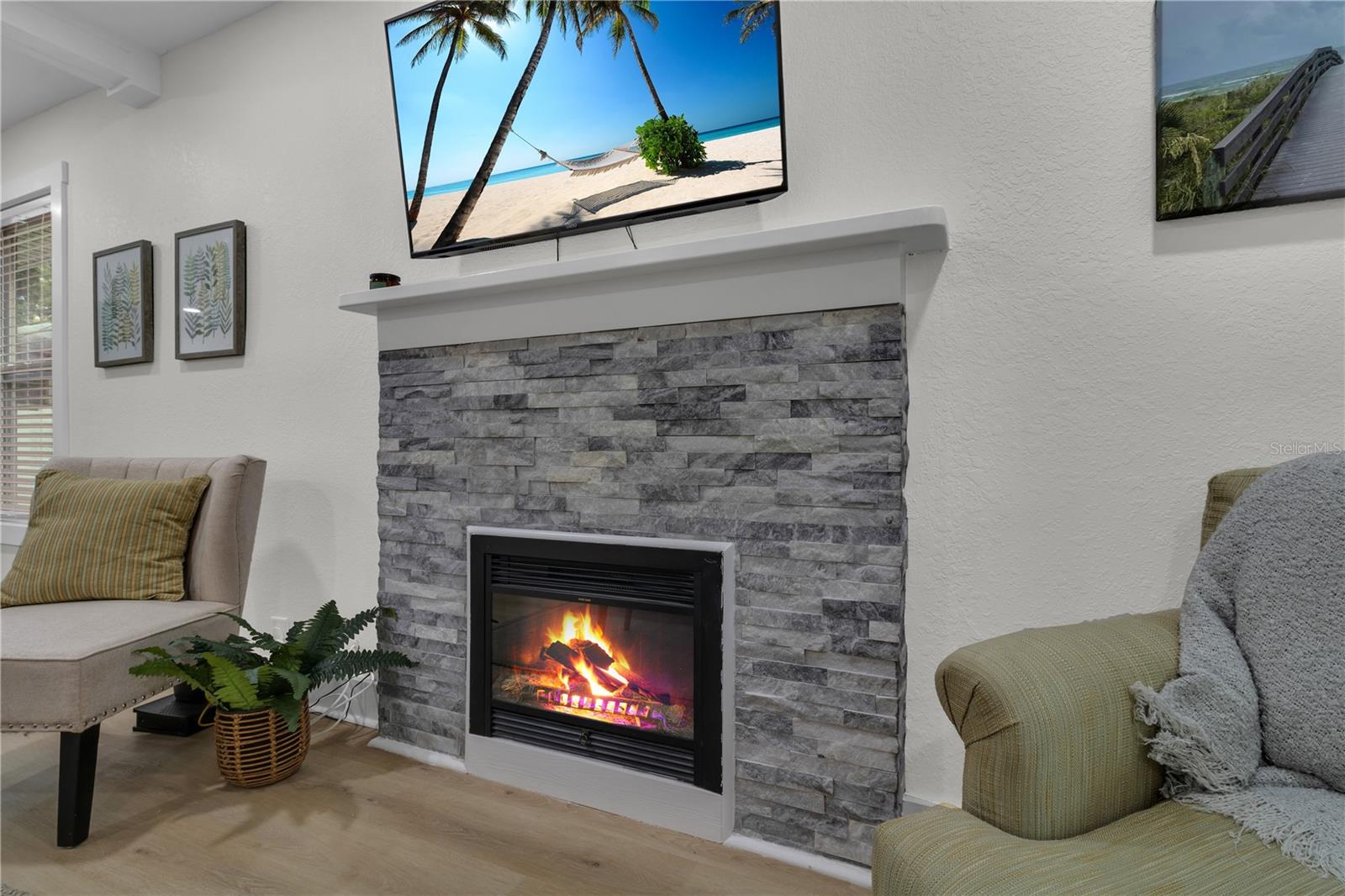 A cozy fireplace serves as the stunning focal point of the living room.