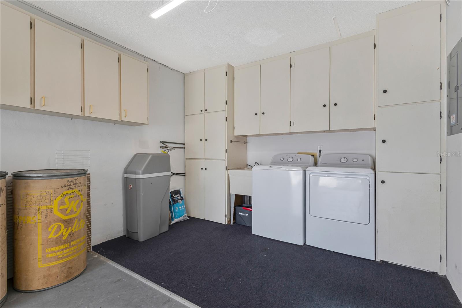 Washer and dryer in garage, utility sink, extra storage cabinets and water softner