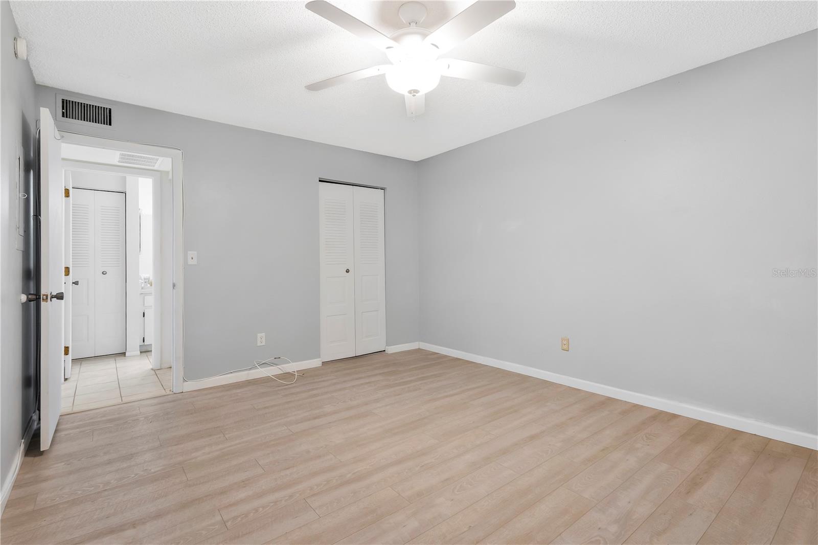 Primary Bedroom with walk in closet and ceiling fan