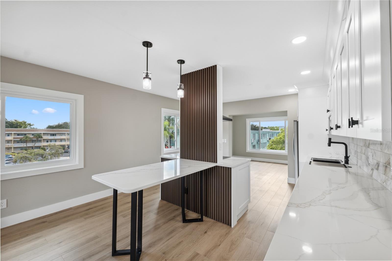 view of kitchen area to back bonus room with large picture window