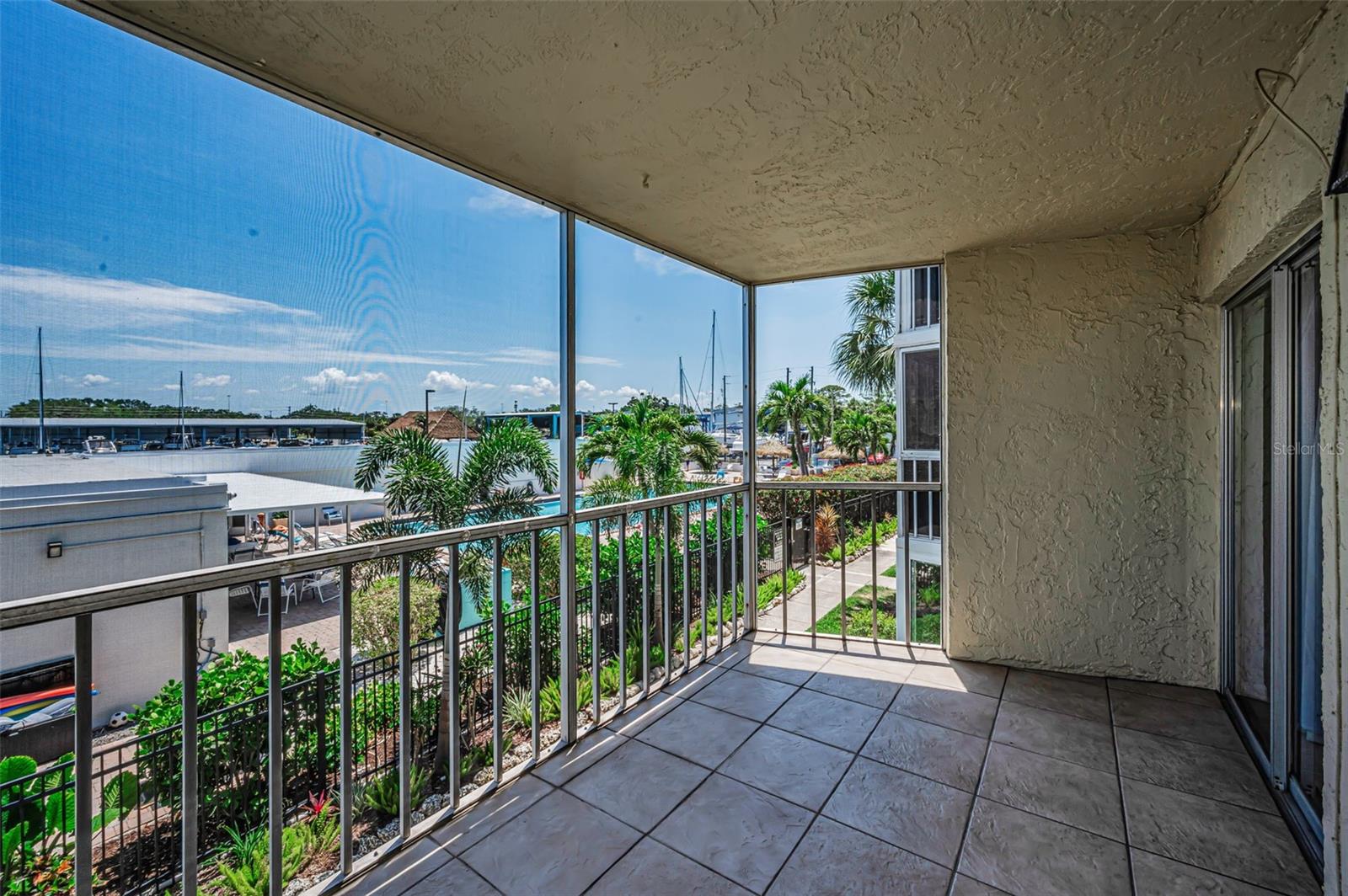 Enjoy your morning coffee on the screened in balcony overlooking both the Marina and Community Pool.