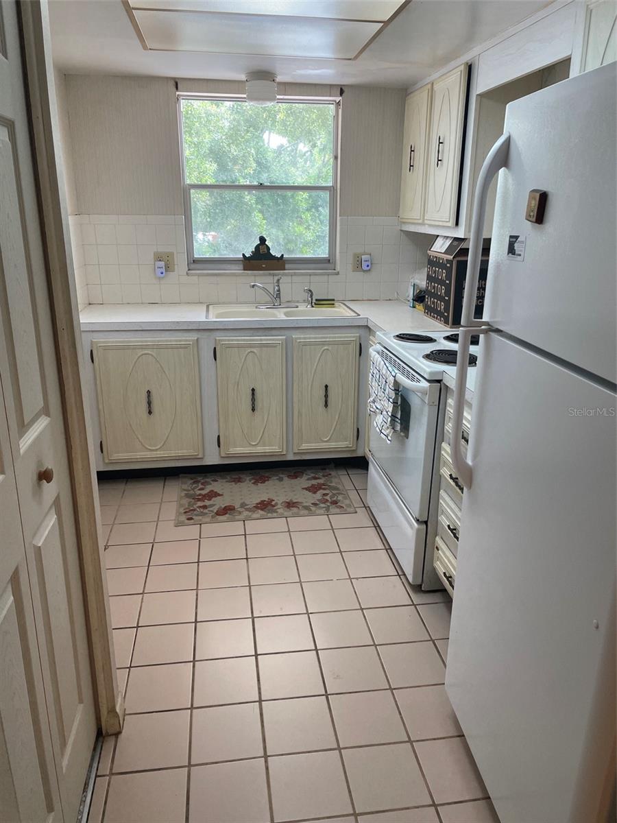 Kitchen has double sink, Fridge and stove/oven.