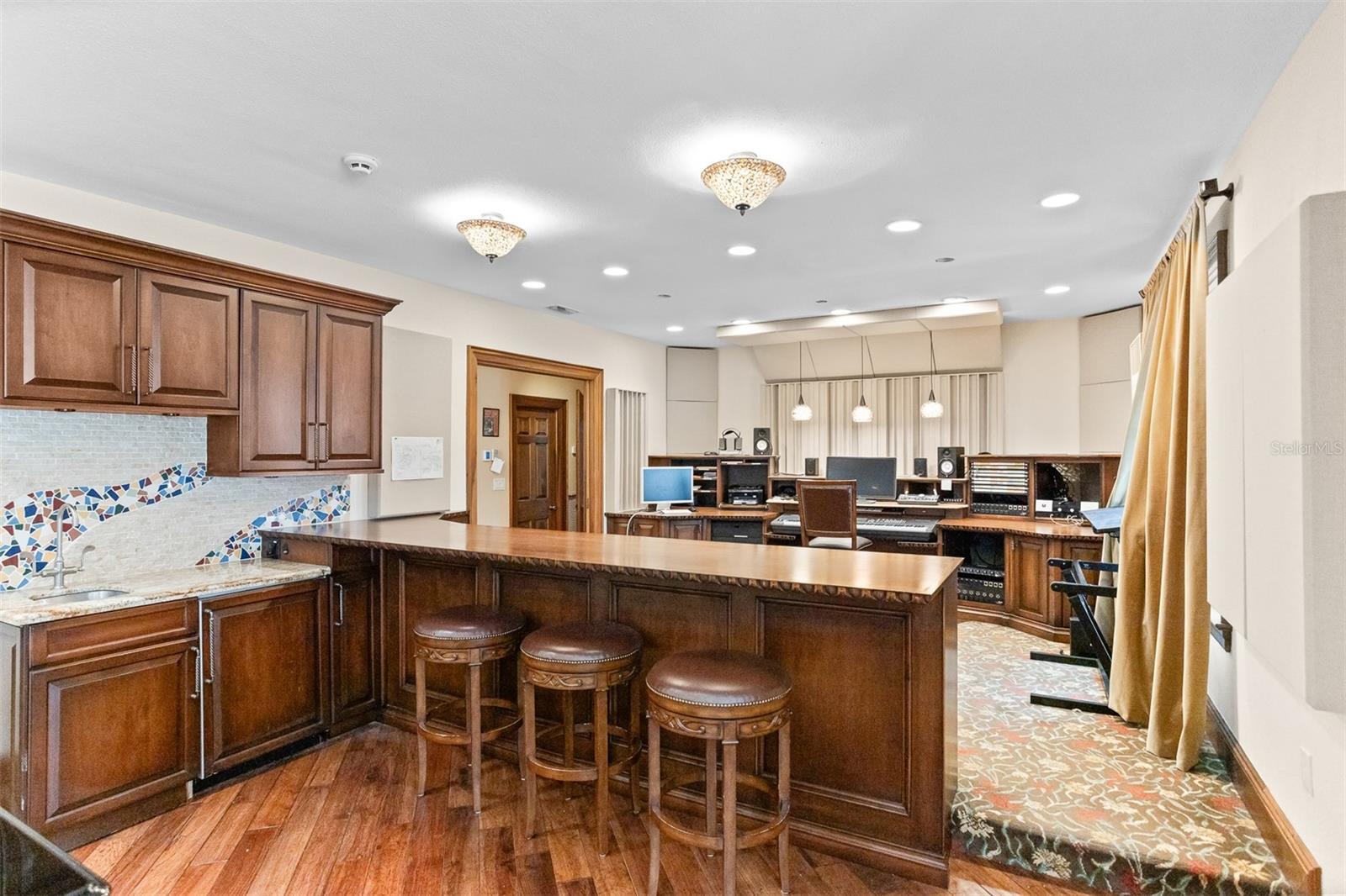 Admire the recording studio from this stylish bar area, complete with sleek barstools and a cozy side kithenette.