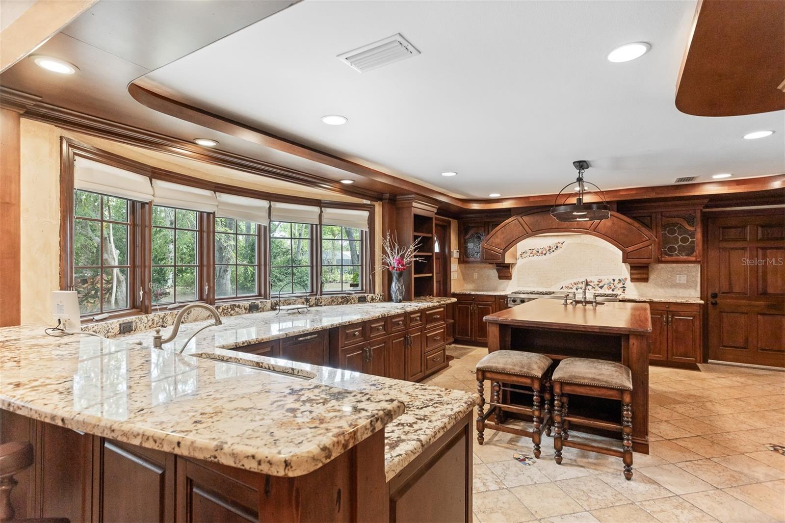 This large, updated, chef's kitchen is the place for small gatherings or large ones, with sleek finishes, custom cabinetry and top-tier appliances-inviting, functional and ready for any occassion.