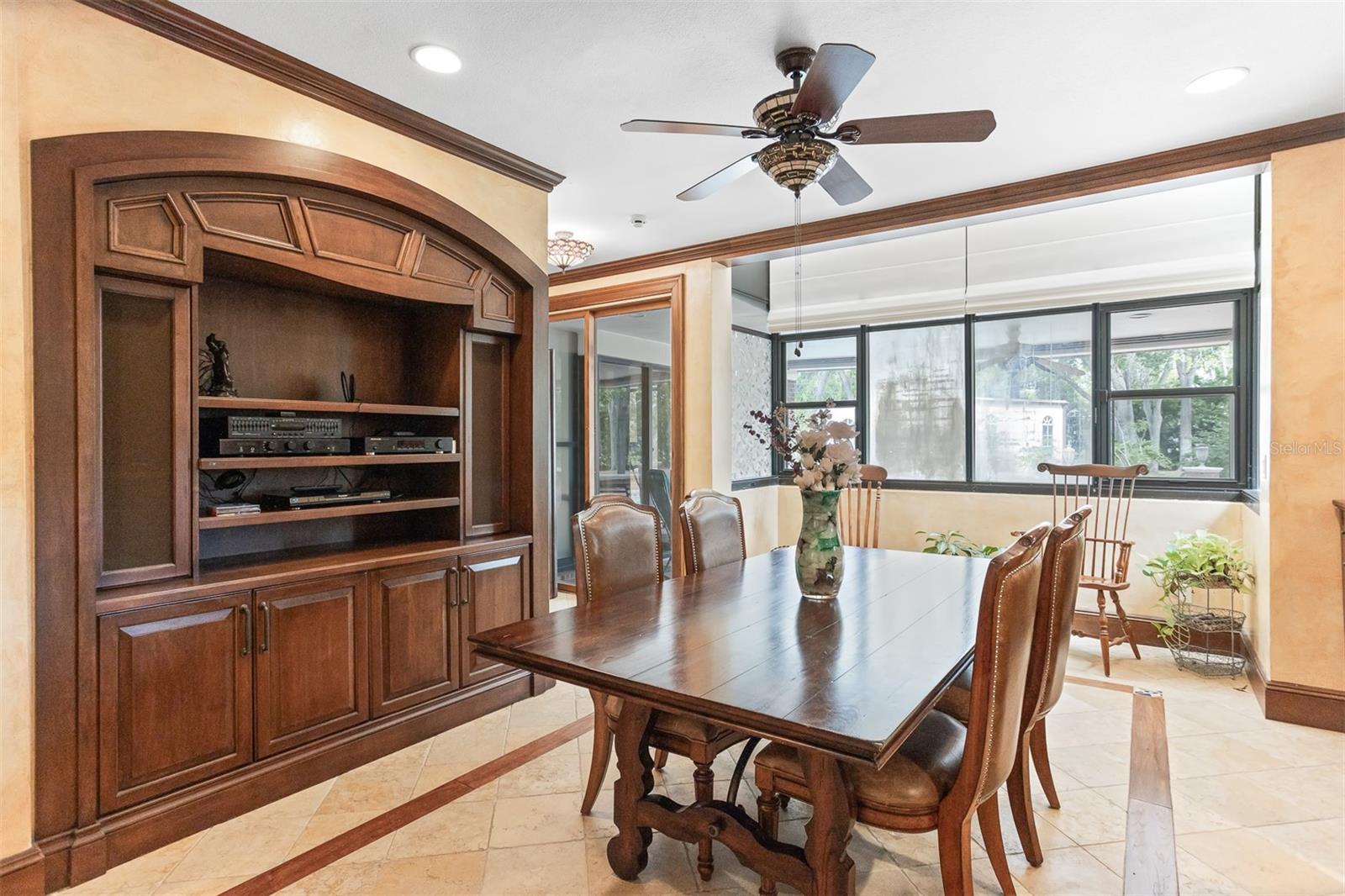 The beautiful eat-in area is anchored by a charming kitchen table, surrounded by custom cabinets and has plenty of natural light pouring in from the windows which overlook the backyard oasis.