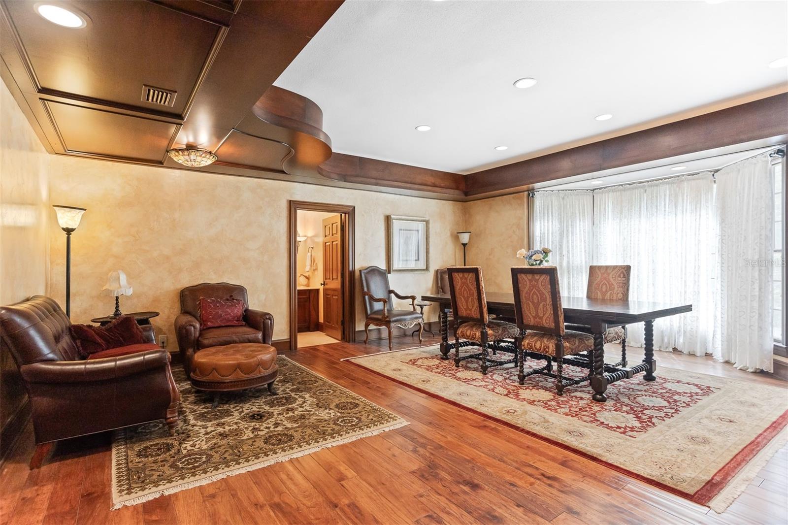 Large dining room with side sitting area, beautiful wood floors and plenty of natural light