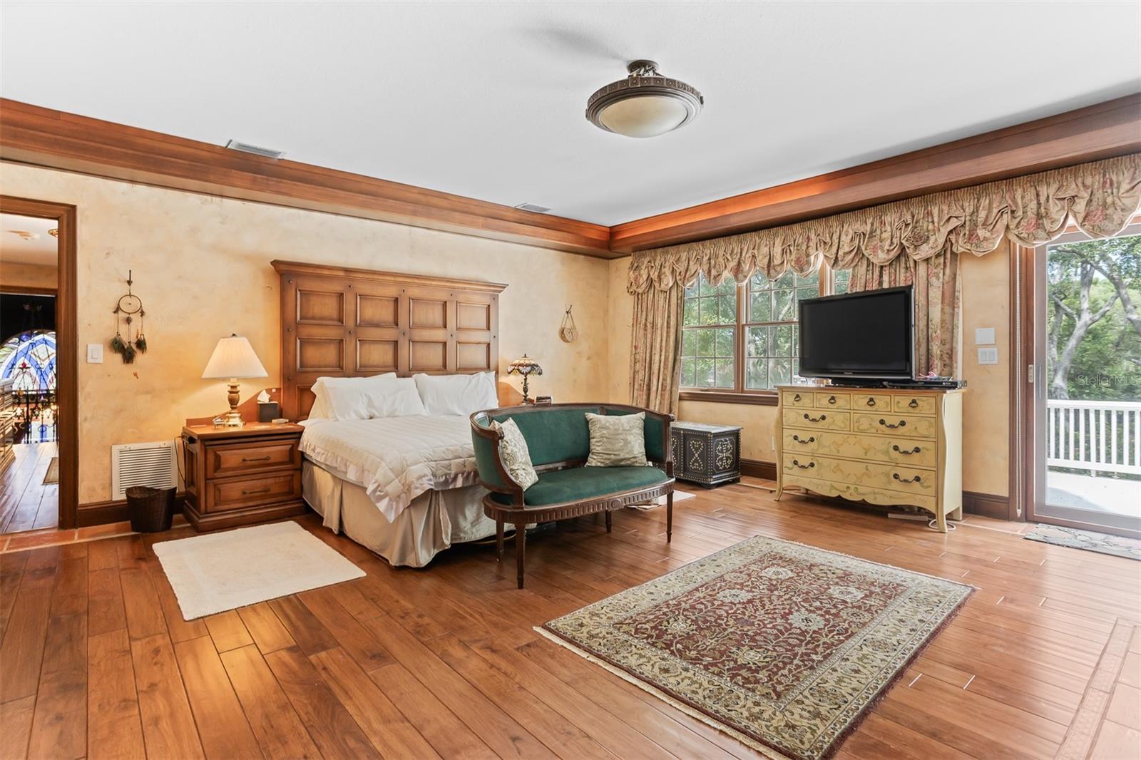 The beautiful primary suite boasts gorgeous wood flooring, a cozy fireplace, abundant natural light and its own private balcony.