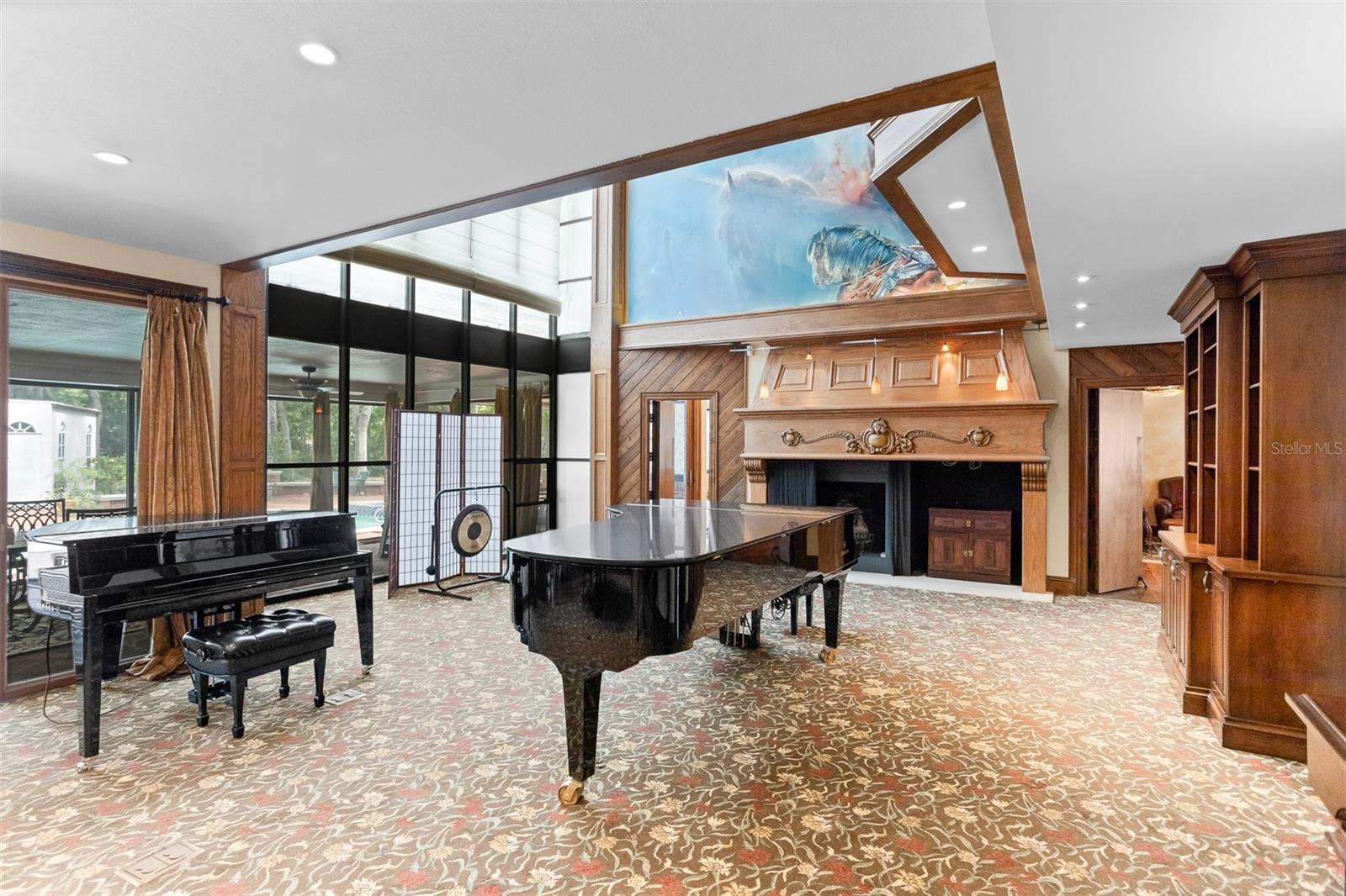 The Grand Great Room is a large, open-hearted space, anchored by a soaring ceiling, a statement fireplace and an abundance of natural light. In the grand room, a cozy sitting area unfolds to the right while the recording studio anchors the back, a space brimming with musical creativity.