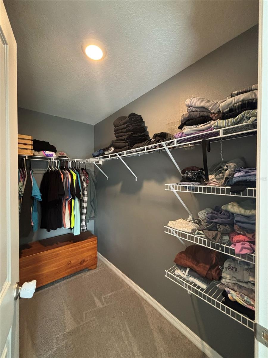 Primary Walk In Closet with additional Storage Behind the Door