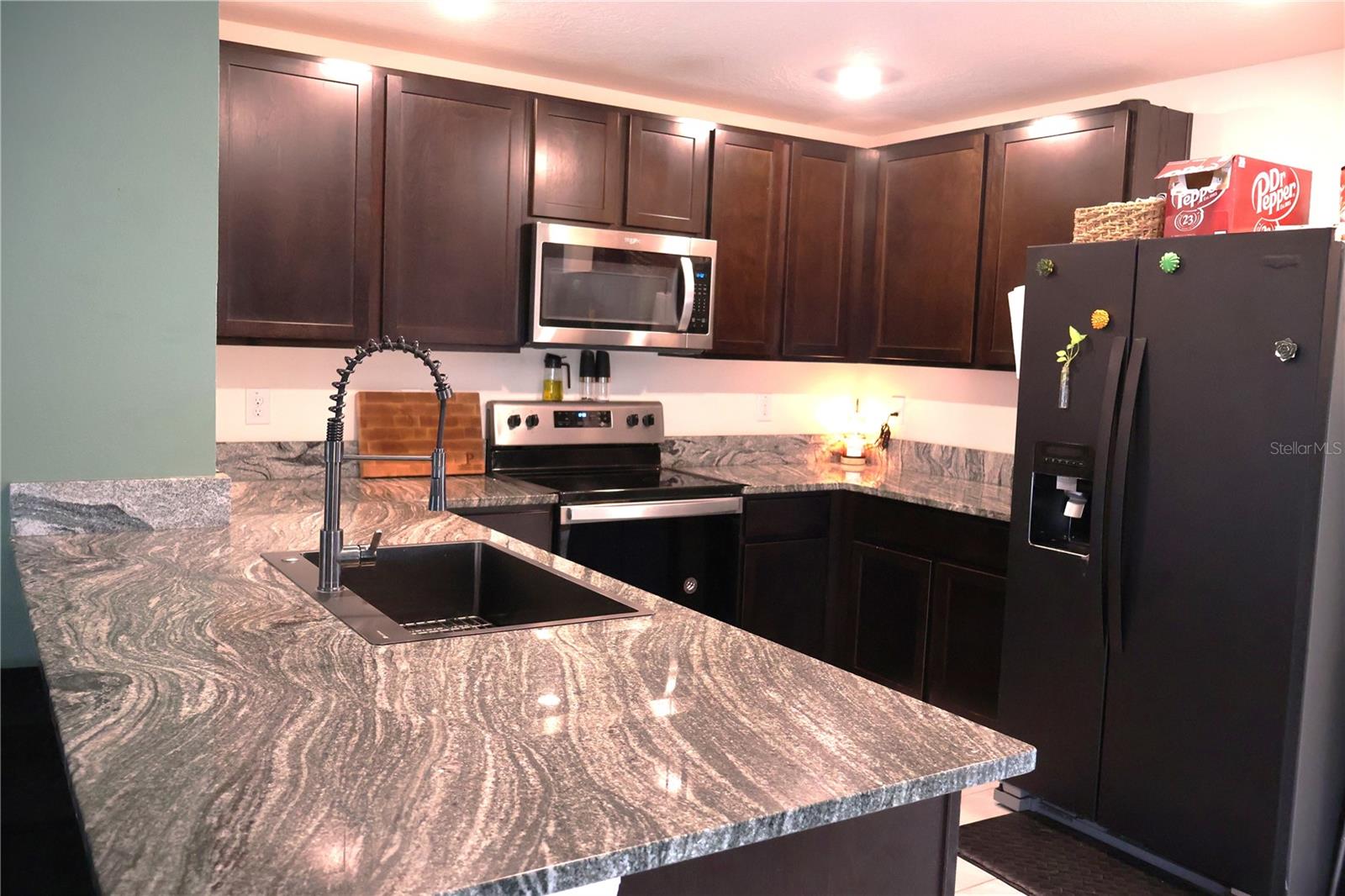 Kitchen with Stunning Granite Countertops and Solid Wood Cabinets. All appliances are Stainless Steel, however the Refrigerator and Dishwasher have been wrapped for protection.