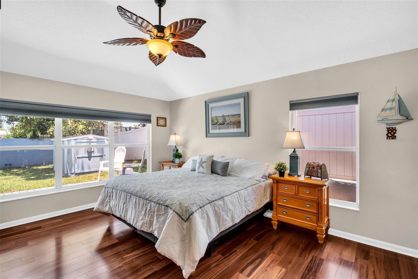 Massive primary retreat featuring soaring vaulted ceilings and oversized windows with peaceful pool views~