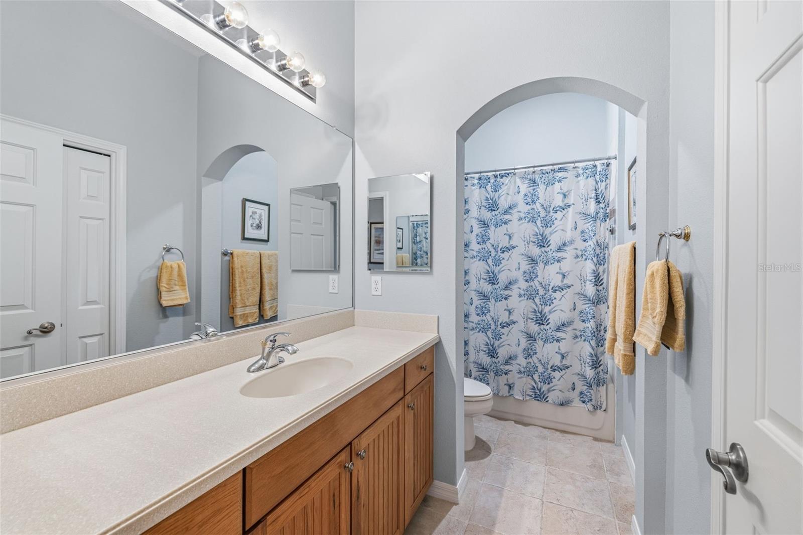 Guest bathroom with long vanity and tub/shower combo