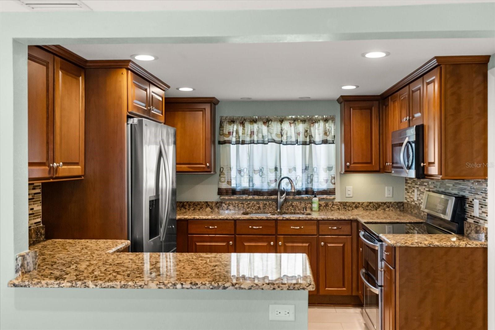 KITCHEN WITH GRANITE COUNTER TOPS AND SOLID WOOD CABINETS