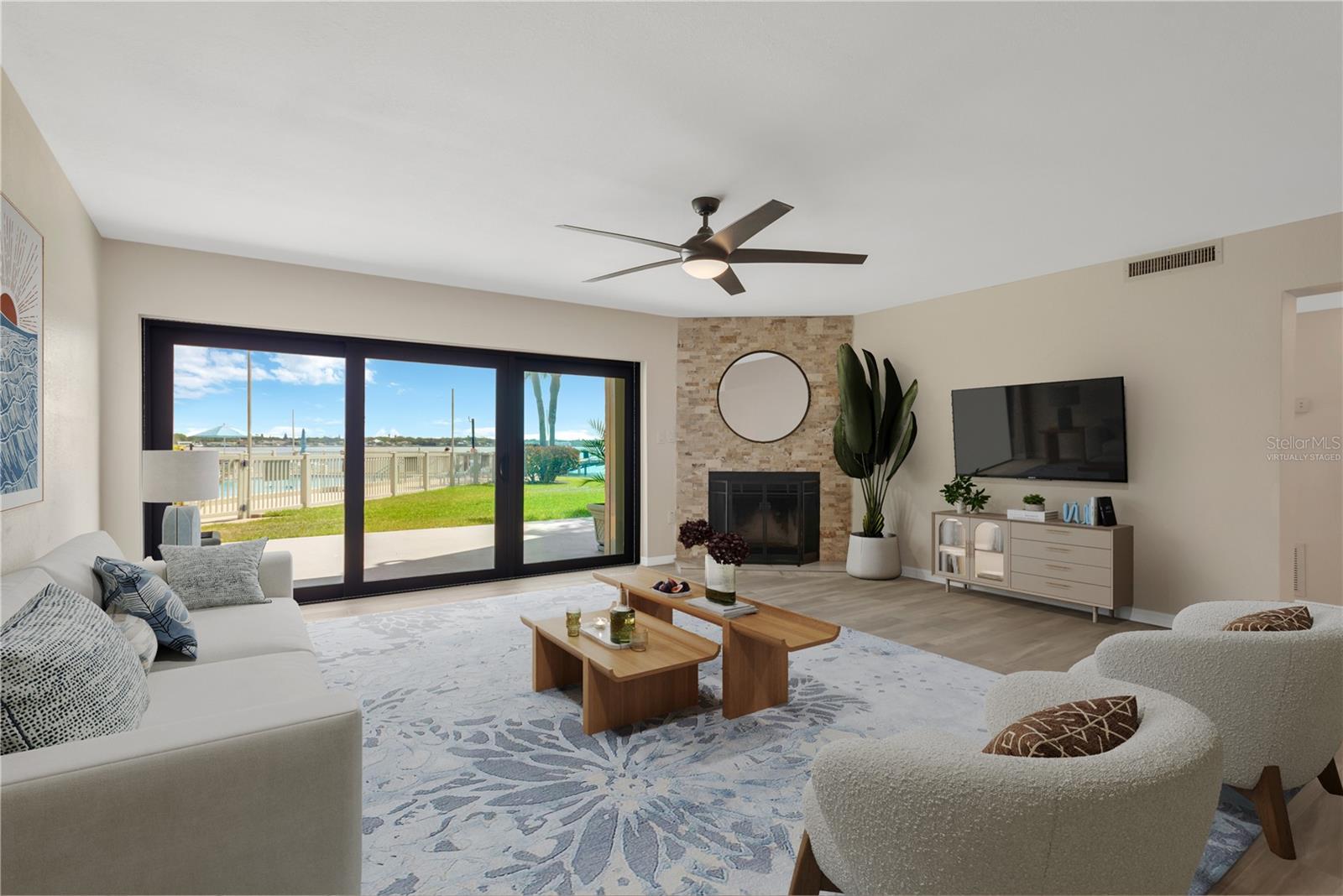 Living room featuring wood burning fireplace and open water views of Tampa Bay