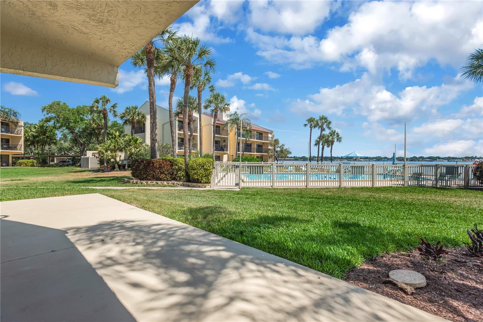 Covered patio off of Primary bedroom with views of Tampa Bay and the Community Pool