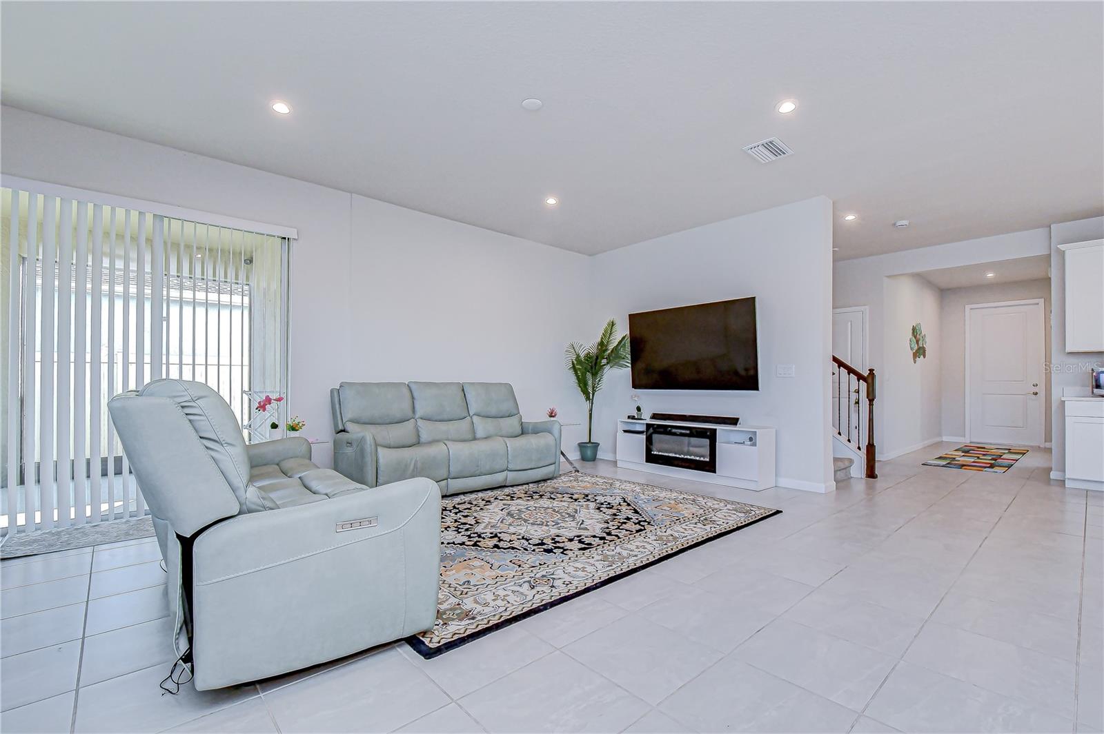 Open-concept living room with sightline to the foyer and front entry.