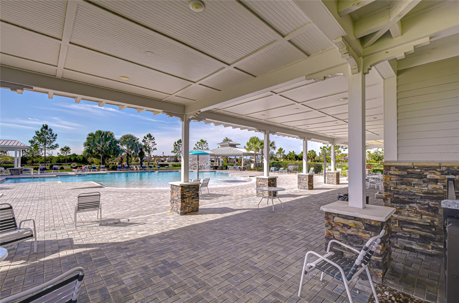 Resort-style pool with shaded seating areas.
