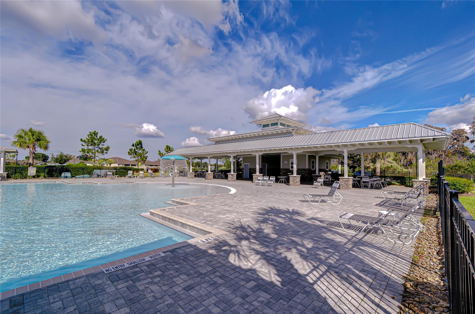 Pool area with clubhouse backdrop.