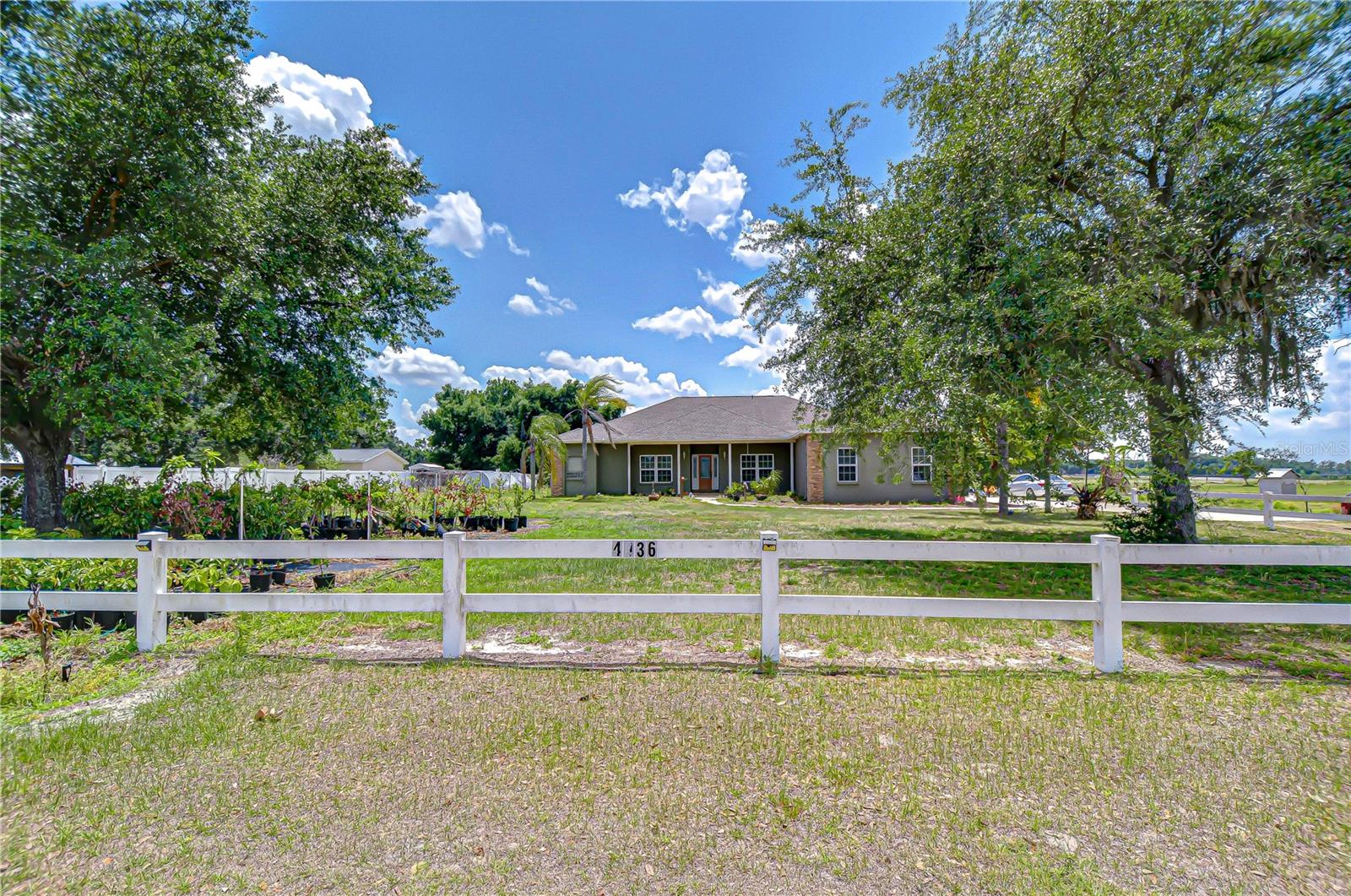 Vinyl-fenced front yard with charming tiled porch