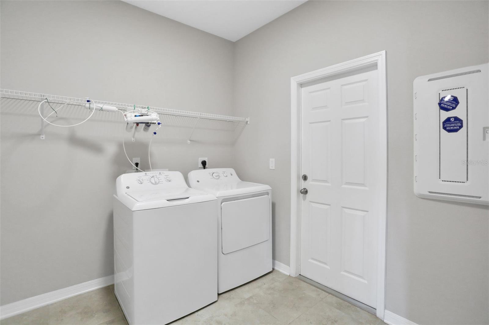 Large laundry room with adjacent under-the-stairs storage