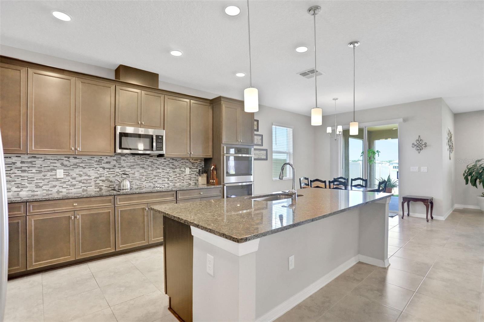 Large kitchen with deluxe built-in double oven, stainless steel appliances, lovely 9-1/2' island breakfast bar, a  walk-in pantry, loads of counterspace and cabinetry.  The cafe/breakfast area is a great location by the sliders, with a water view.