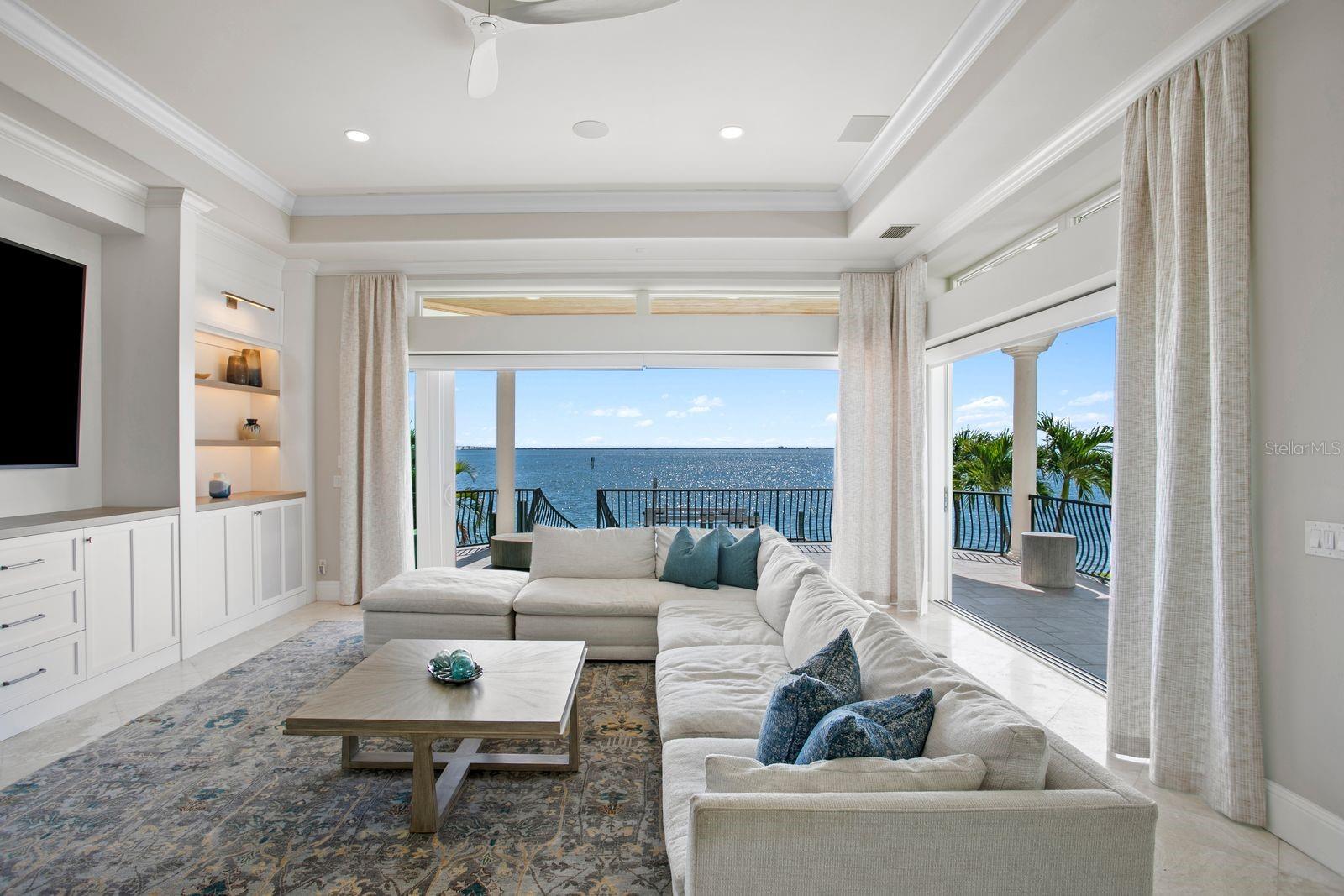Another stunning perspective of the family room showcasing the fully opened sliders and seamless indoor-outdoor living.