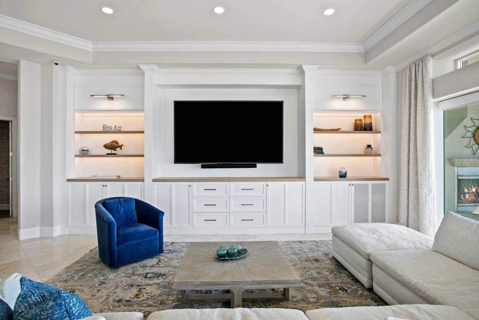 The family room features a beautifully designed entertainment wall with custom built-in cabinetry and integrated media space.