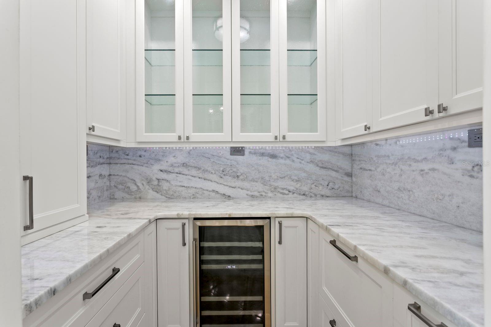 A sophisticated butler's pantry located just off the kitchen offers an expansive prep area for entertaining and includes a wine refrigerator.