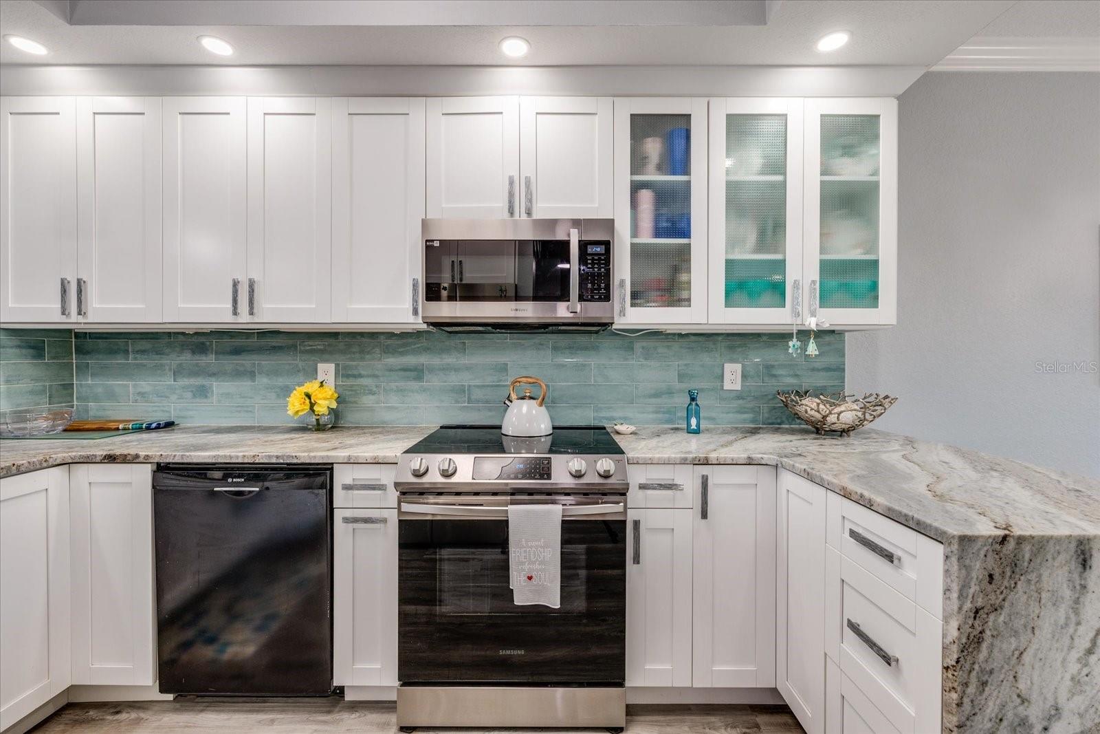 Updated gourmet kitchen with granite featuring waterfall edge