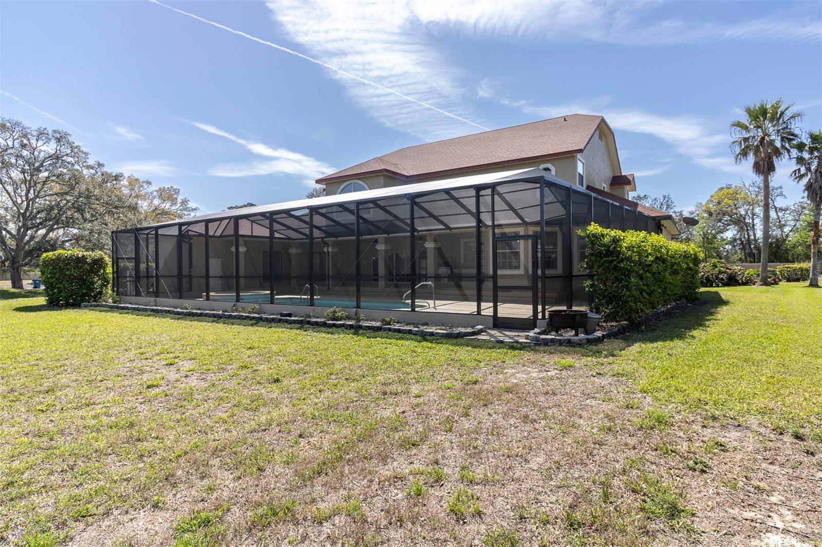Back yard with pool cage