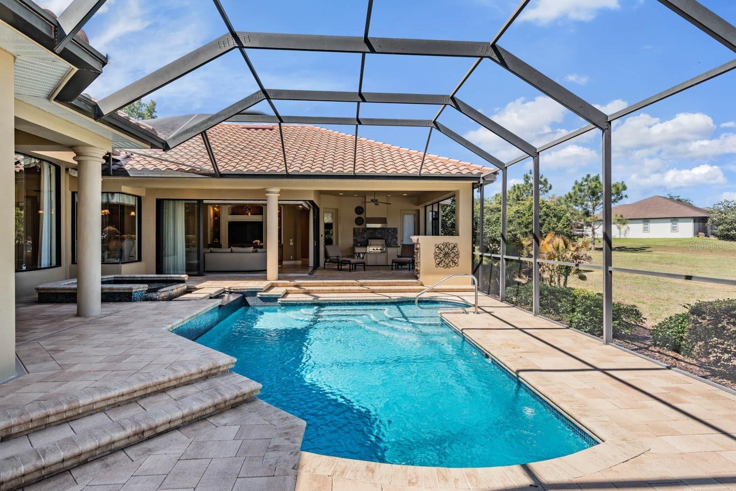 Paver pool deck with covered patios and soothing water features
