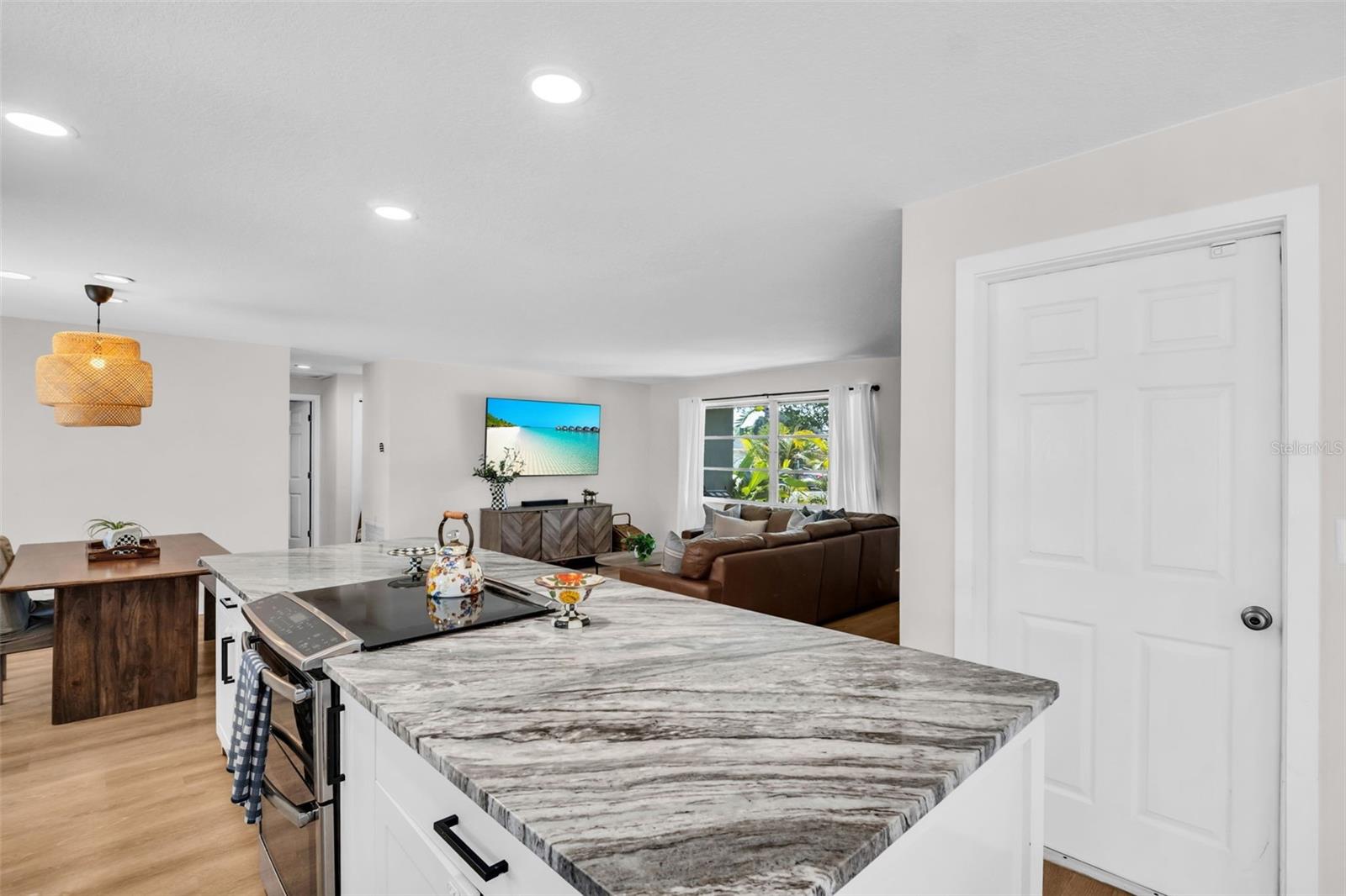 Sleek stainless appliances, recessed lighting, and updated white cabinetry~