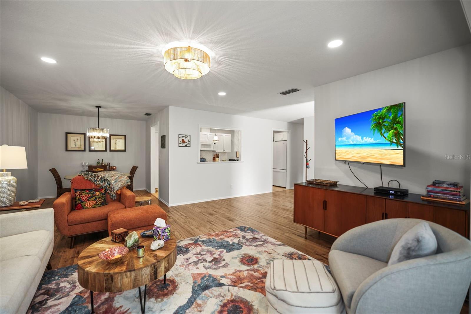 Living room open to dining room and showing pass through to the kitchen with engineered hardwood flooring