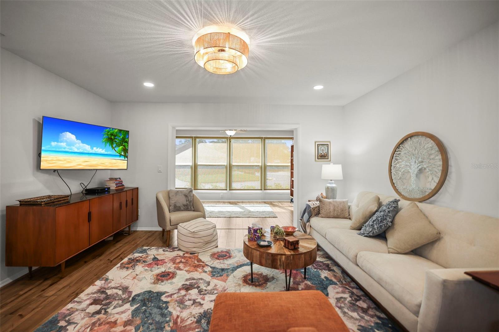 Living room open to enclosed lanai with engineered hardwood flooring