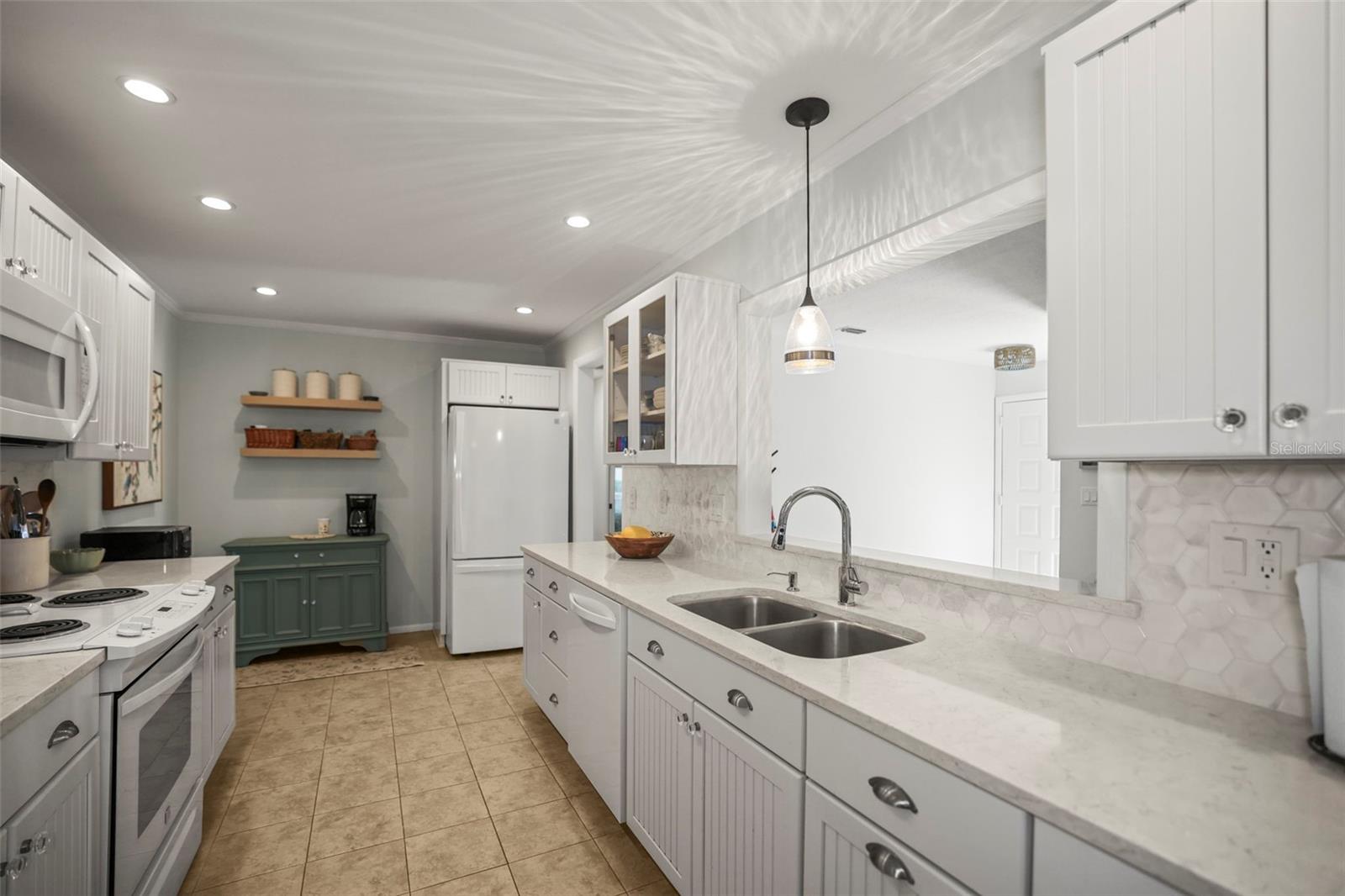 Kitchen with Solid surface counters, hardwood beadboard cabinetry, ceramic tile flooring and a pass through to the living room